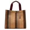 A tan canvas crossbody tote bag with brown stripes and a maroon strap.