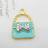 A set of six crystal enamel handbag charm pendants featuring a gold-toned loop and a light blue rectangular charm with a whit