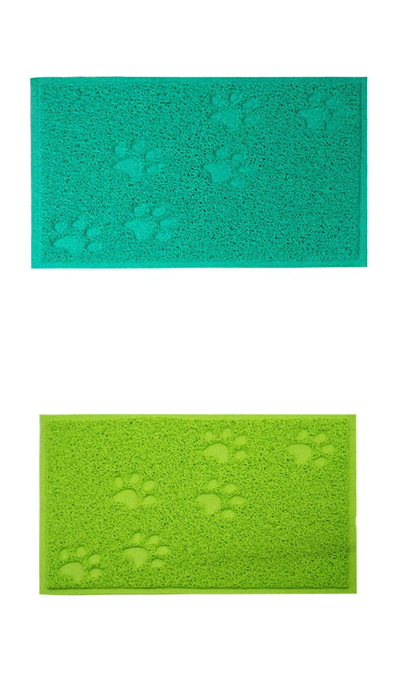 A teal cat litter mat with a textured surface featuring paw print designs.