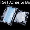 Clear self-adhesive bags for storage, showing various clear plastic bags and white adhesive pads.
