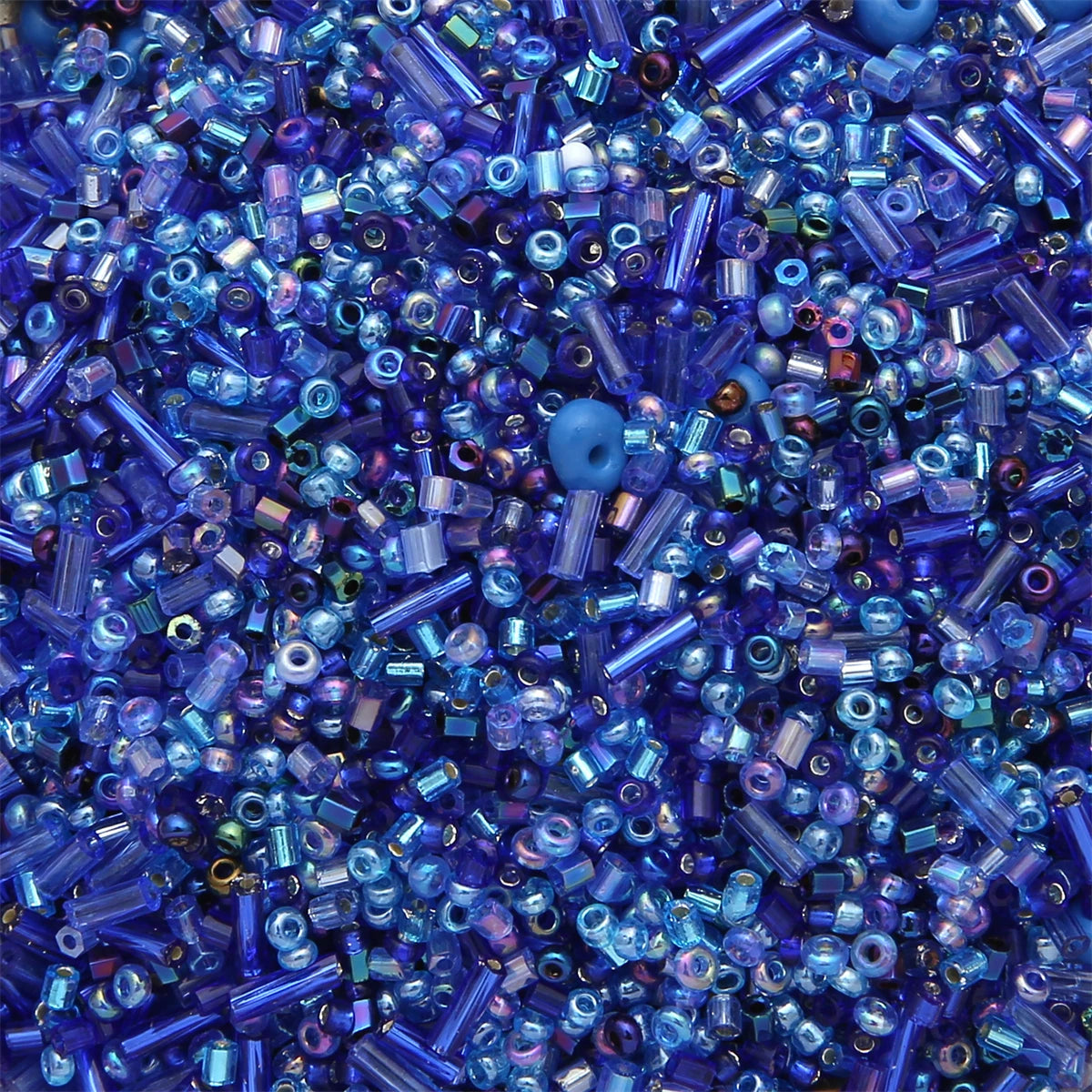 A close-up view of mixed glass seed beads in various shades of blue and purple.