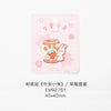 A pink tag featuring an embroidered illustration of a cute white rabbit next to a baked food item.