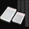 A collection of clear self-adhesive resealable storage bags in various sizes and dimensions displayed on a dark background.