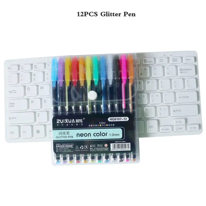 A set of 12 glitter pens in various colors including neon and pastel shades displayed next to a laptop keyboard