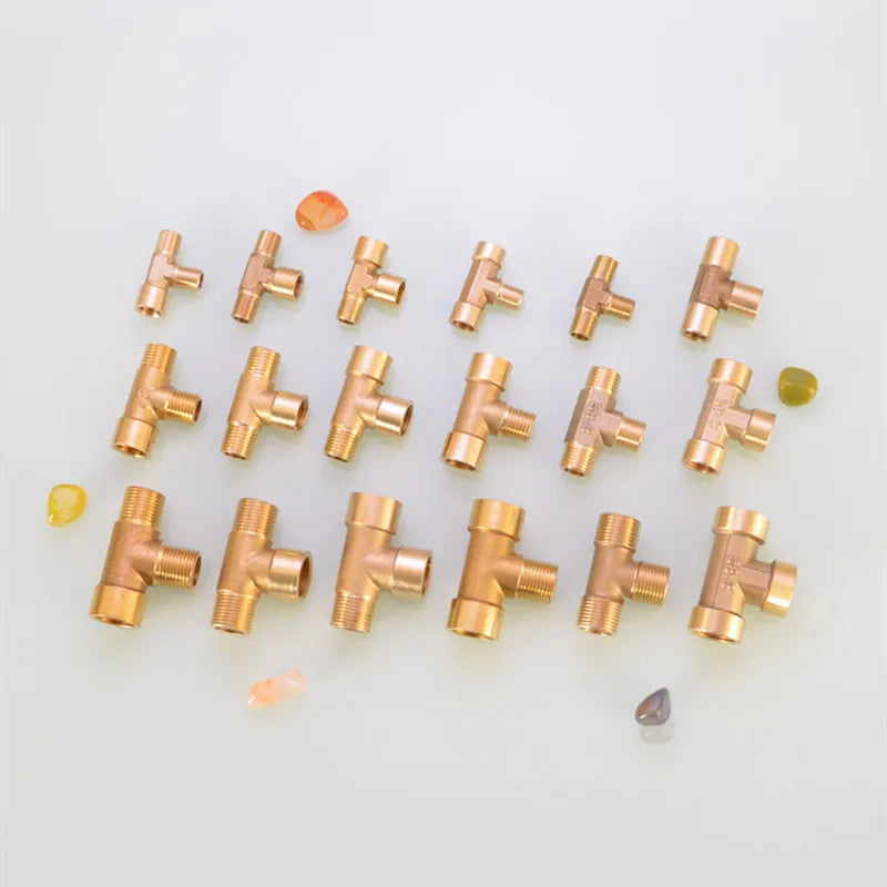 A collection of brass BSP tee pipe fittings for various connections, arranged on a light surface.
