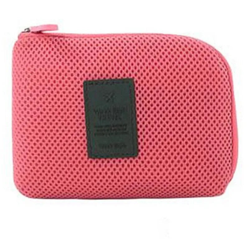 A pink mesh pouch for organizing travel cables and accessories.