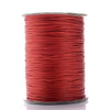 A spool of red waxed cotton cord used for jewelry making