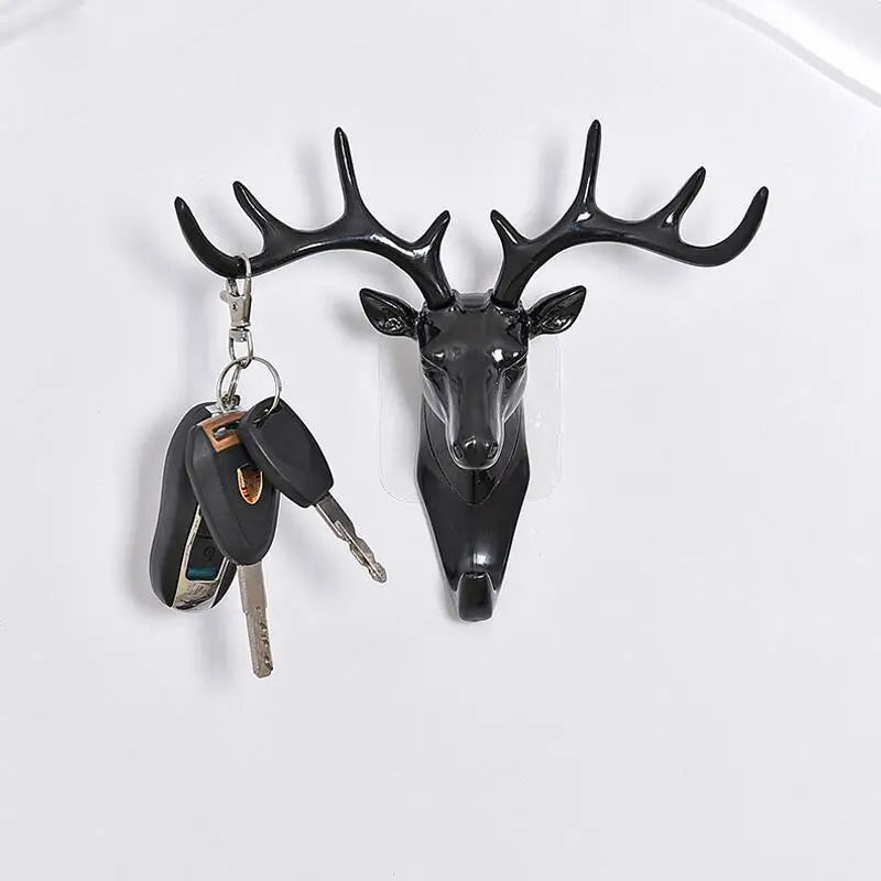 A black deer head wall hook featuring antlers, used for hanging hats, scarves, or keys.