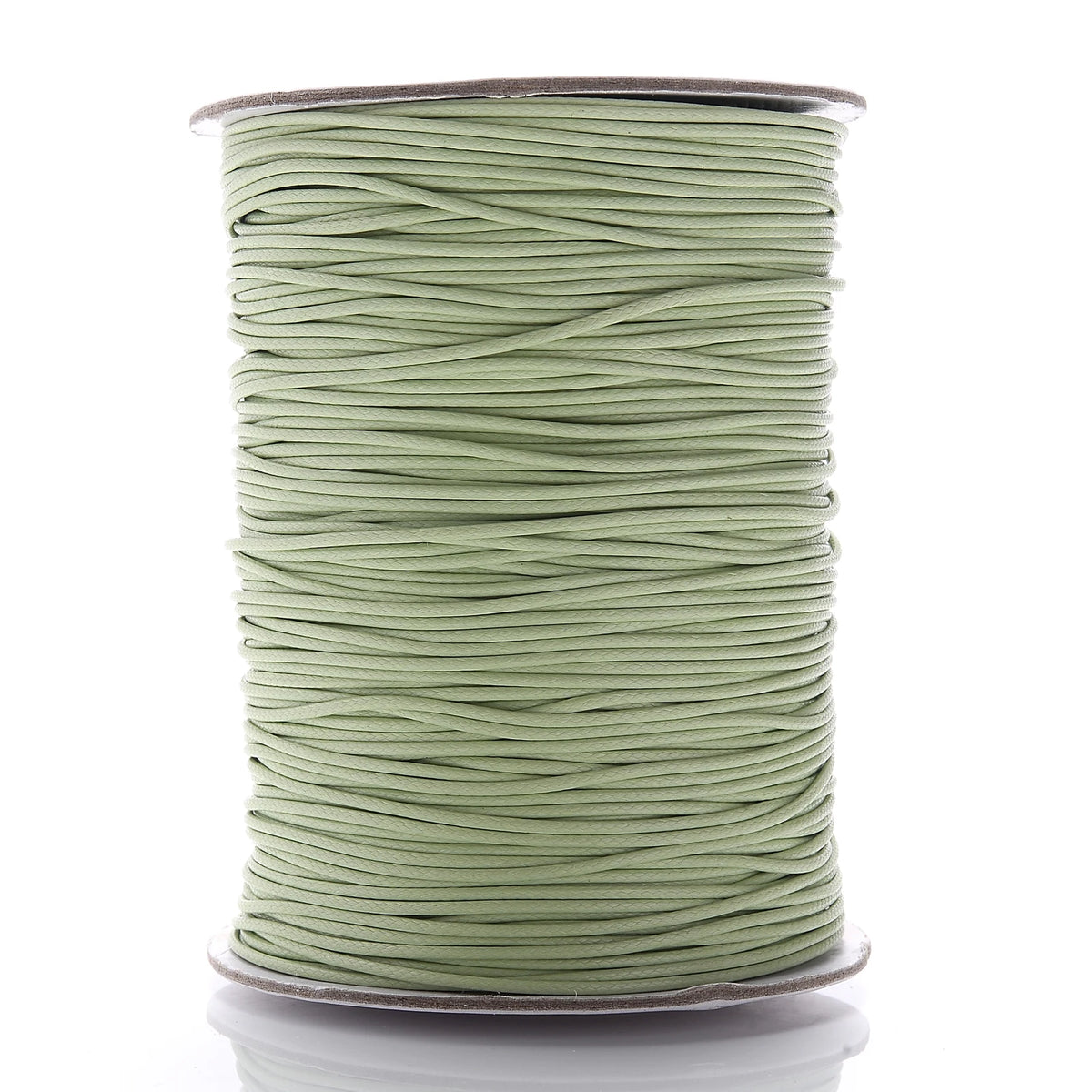 A spool of light green waxed cotton cord used for jewelry making
