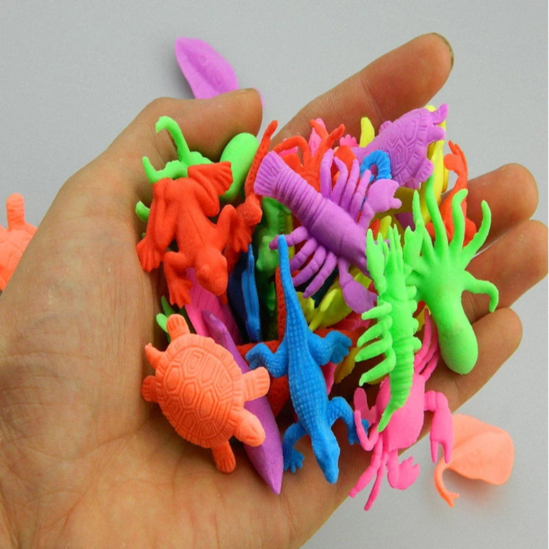 A hand holds a collection of colorful magical water-growing ocean animal toys for kids.