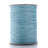 A spool of teal waxed cotton cord used for jewelry making