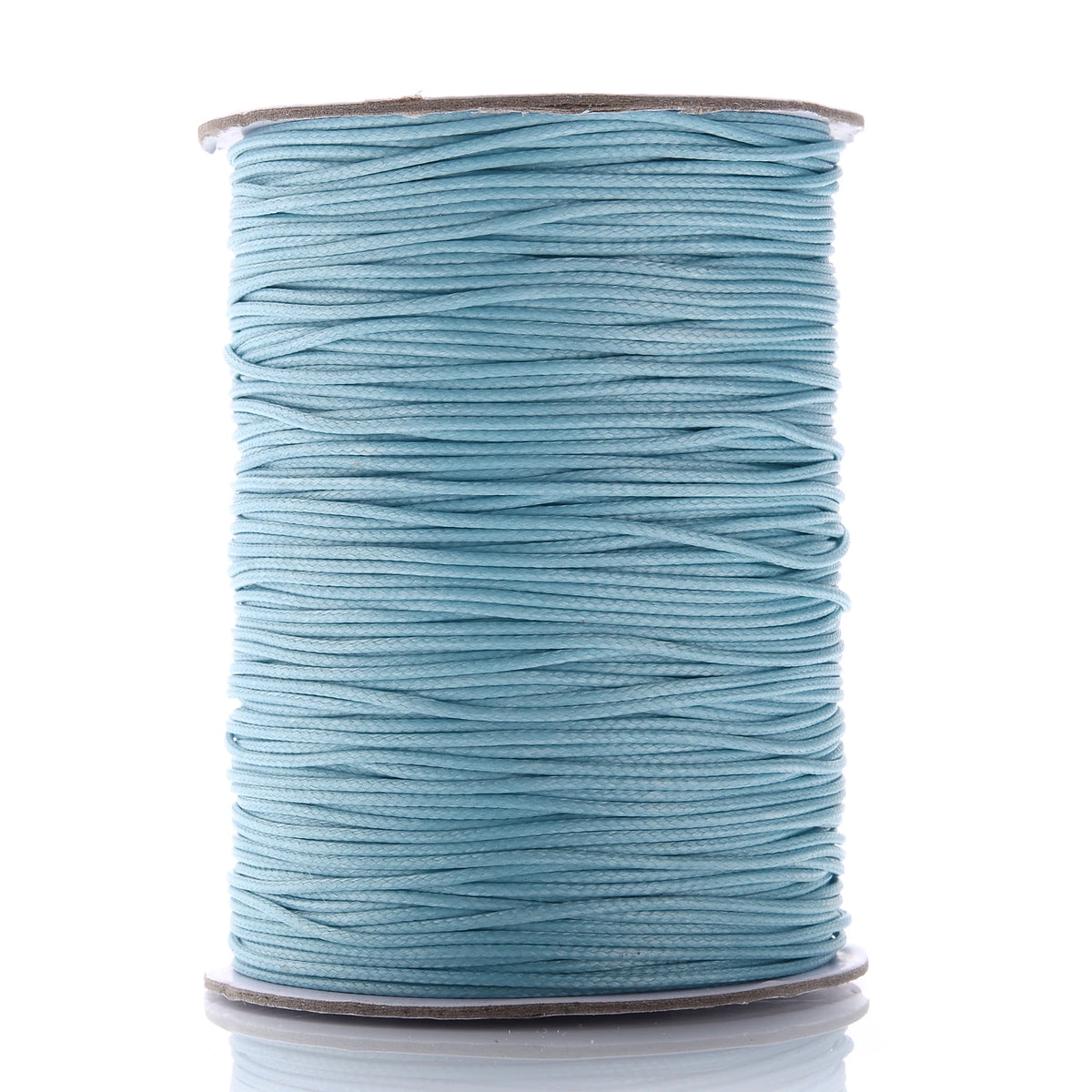 A spool of teal waxed cotton cord used for jewelry making