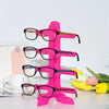 A bright pink stackable display stand holding several pairs of eyeglasses and sunglasses.