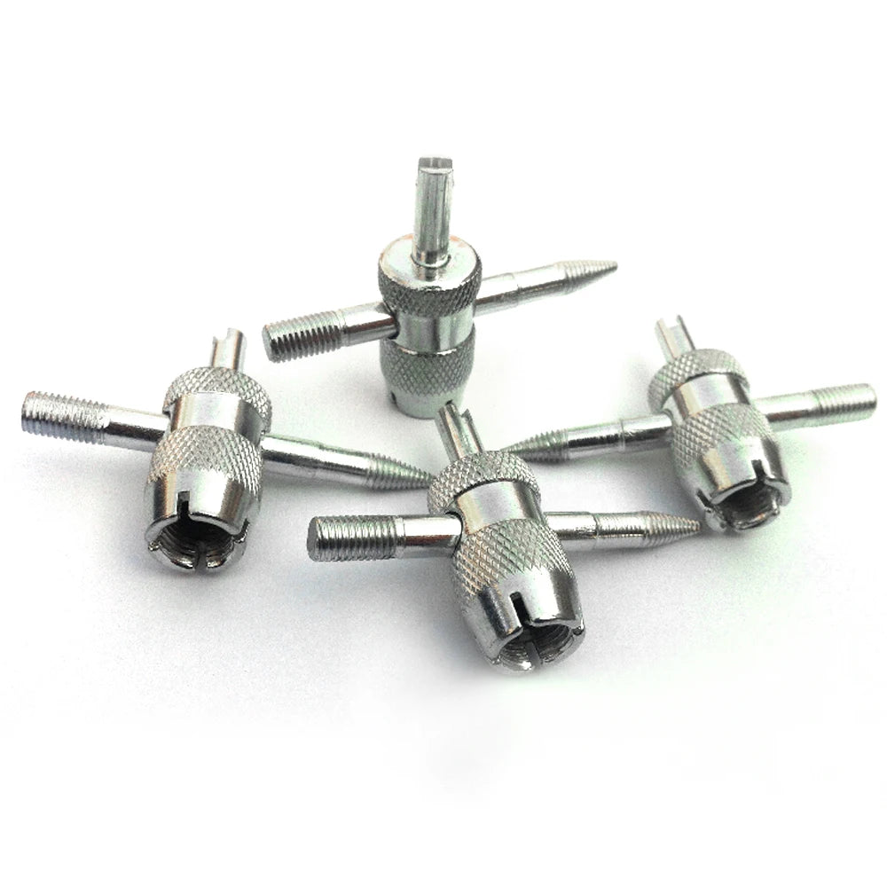 Un jeu de quatre outils métalliques pour réparer les valves de pneus, de différentes tailles et pointes.