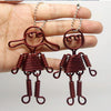 Pair of reddish-brown jewelry wire necklaces with decorative elements shown on a hand.