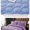 Purple quilted velvet bedspread with a diamond pattern and a blue textured fabric background.
