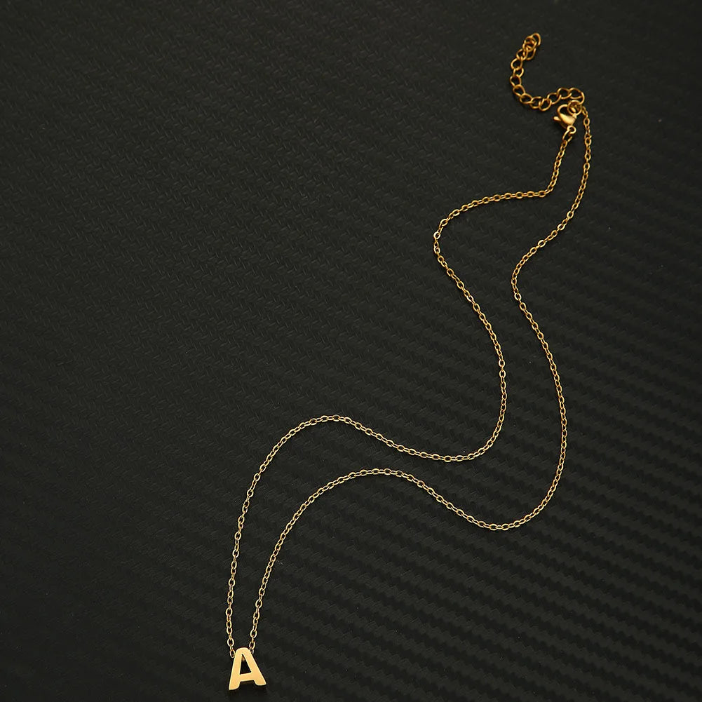 A gold chain necklace with the letter A pendant displayed against a dark background.