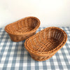 A brown handwoven wicker serving basket sitting on a blue and white checkered tablecloth.