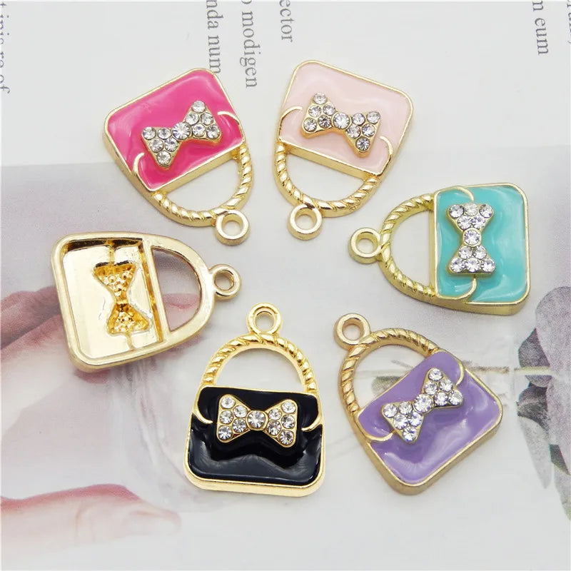 A set of six crystal enamel handbag charm pendants in various colors and finishes, including pink, mint green, gold, and purp