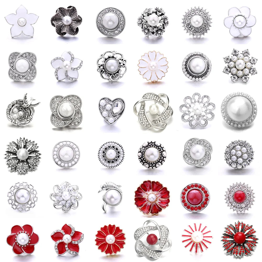 A collection of various silver and white metal snap buttons for jewelry making, including floral and round designs.