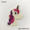 A light beige felt embroidered patch of a unicorn head with pink and purple accents.