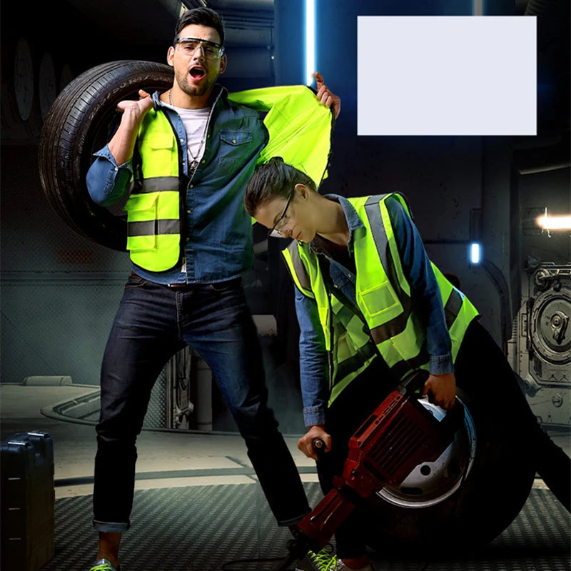 A man wearing a blue shirt and dark pants holds a yellow high-visibility safety vest while another person is visible in the b