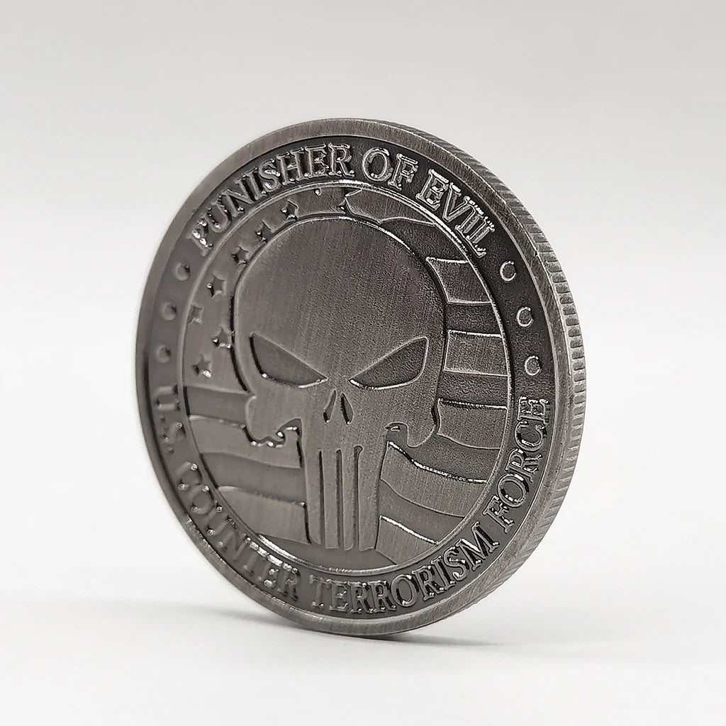 A round, silver-toned commemorative coin featuring a stylized skull and crossbones design.