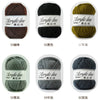 A collection of soft acrylic yarn balls in various colors and thicknesses, including brown, black, olive green, gray, and nav
