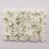 A dense wall panel made of white silk rose flowers for weddings and events.