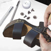 A professional leather craft tool kit showing a leather tool, various metal tools, and leather pieces being worked on.
