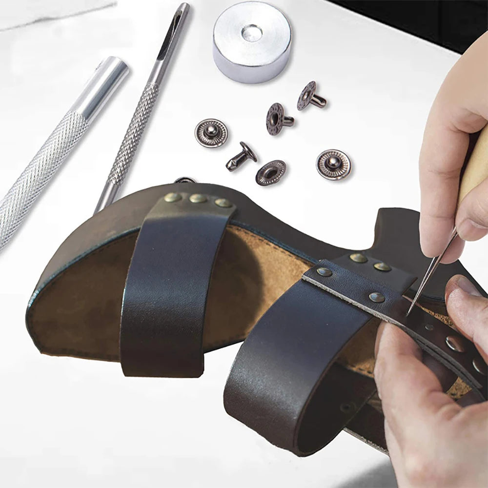 A professional leather craft tool kit showing a leather tool, various metal tools, and leather pieces being worked on.