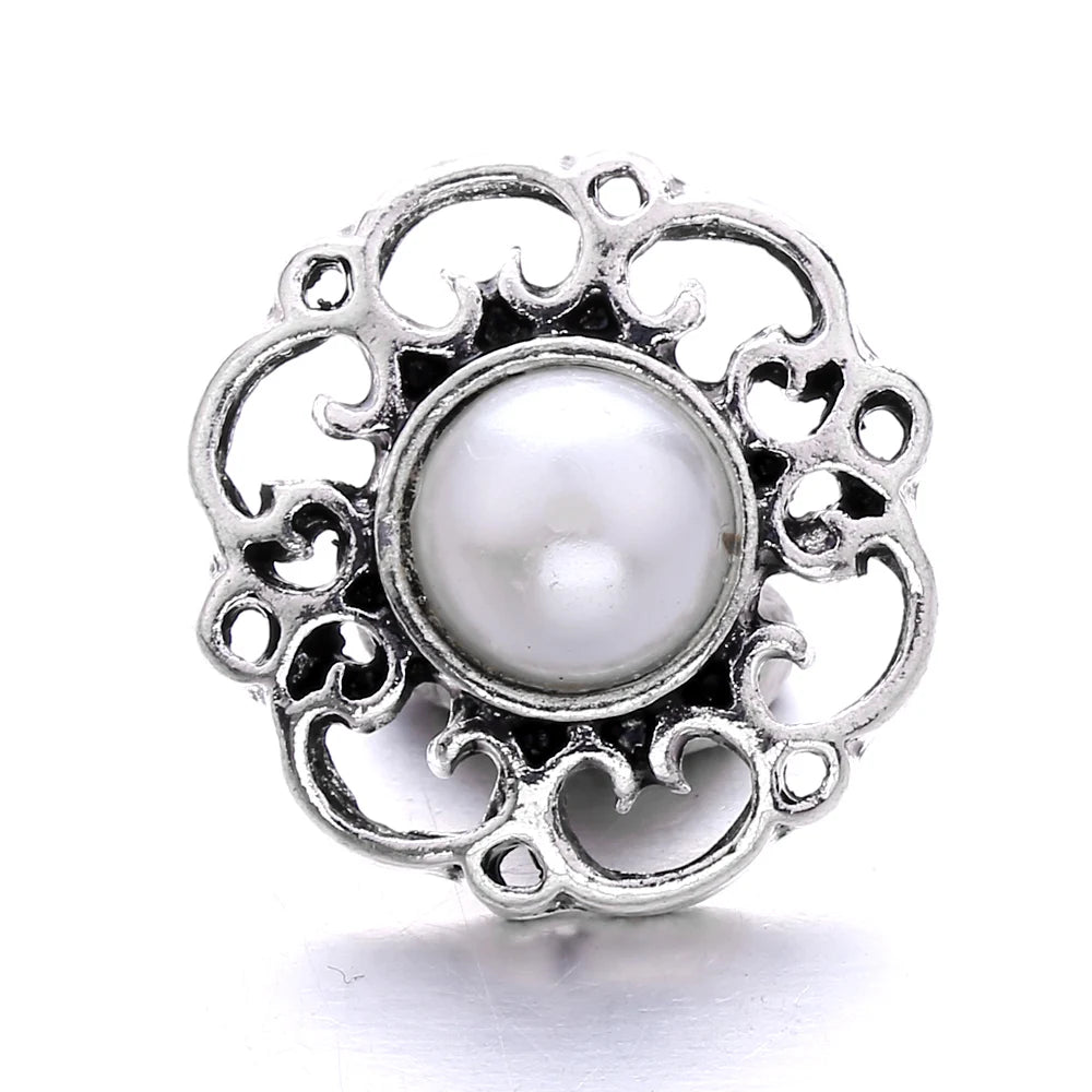 Silver metal snap button with a round pearl centerpiece for jewelry making