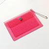 A pink glitter PVC card holder with a silver clasp and a chain attached.