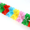 A colorful set of paper flowers in various shades including red, orange, blue, yellow, and green.