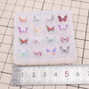 A clear silicone mold containing multiple butterfly shaped epoxy resin pieces for DIY jewelry making