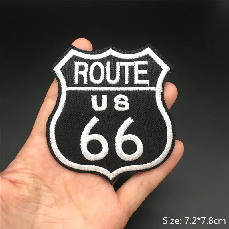 Black embroidered route us 66 shield patch held in a hand