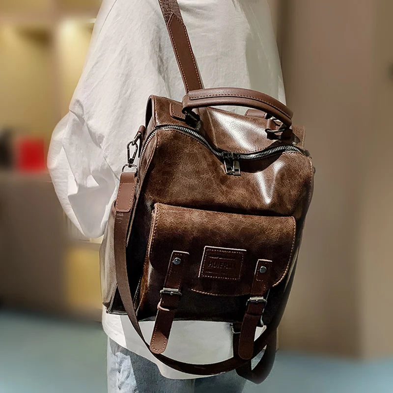A brown PU leather fashion backpack carried by a person wearing a white shirt.