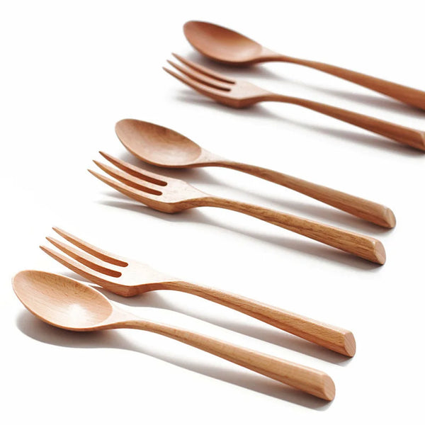 A set of natural beech wood cutlery including spoons and forks arranged diagonally on a white background.