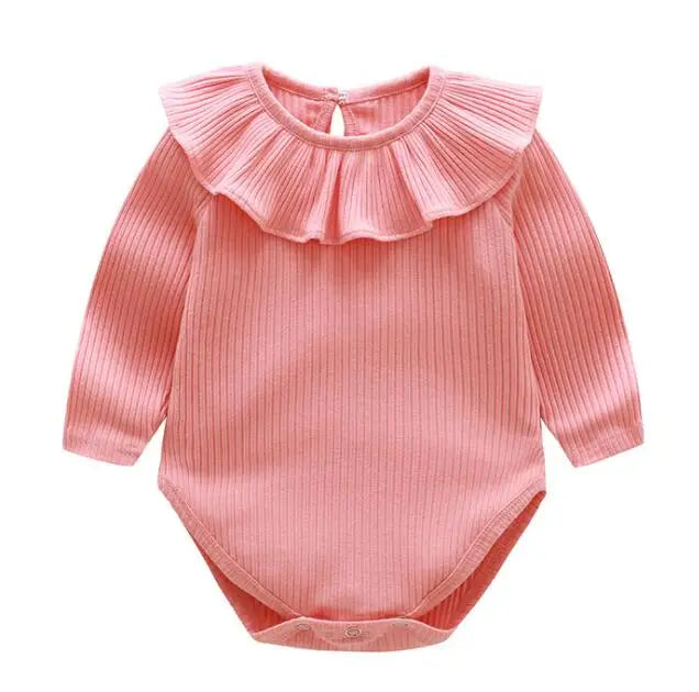 A pink ribbed cotton romper for a baby girl with a ruffled neckline.