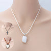 A white leather cord necklace with a silver cross pendant displayed on a mannequin neck.