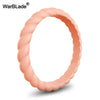 A close-up view of a braided silicone ring in a soft peach or nude color.