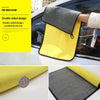 A yellow and gray double-sided microfiber car wash cleaning towel is shown being used on a car window.