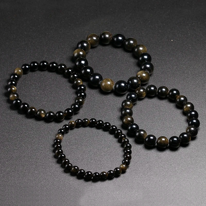 A set of handmade stretch bracelets featuring natural black and gold obsidian gemstones.