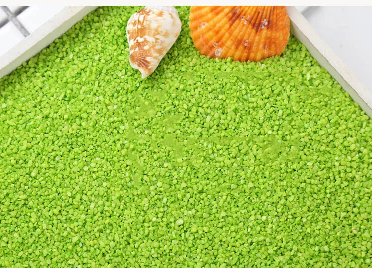 Green decorative stone pebbles for terrariums and aquariums with a seashell visible on top