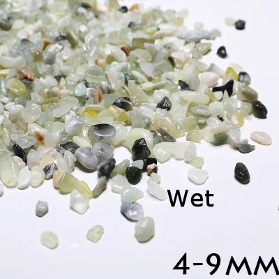 A pile of wet decorative stone pebbles ranging in color from pale green to gray and black, measuring 4-9 mm.
