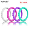Four silicone rings in white, pink, purple, and teal colors displayed on a reflective surface.