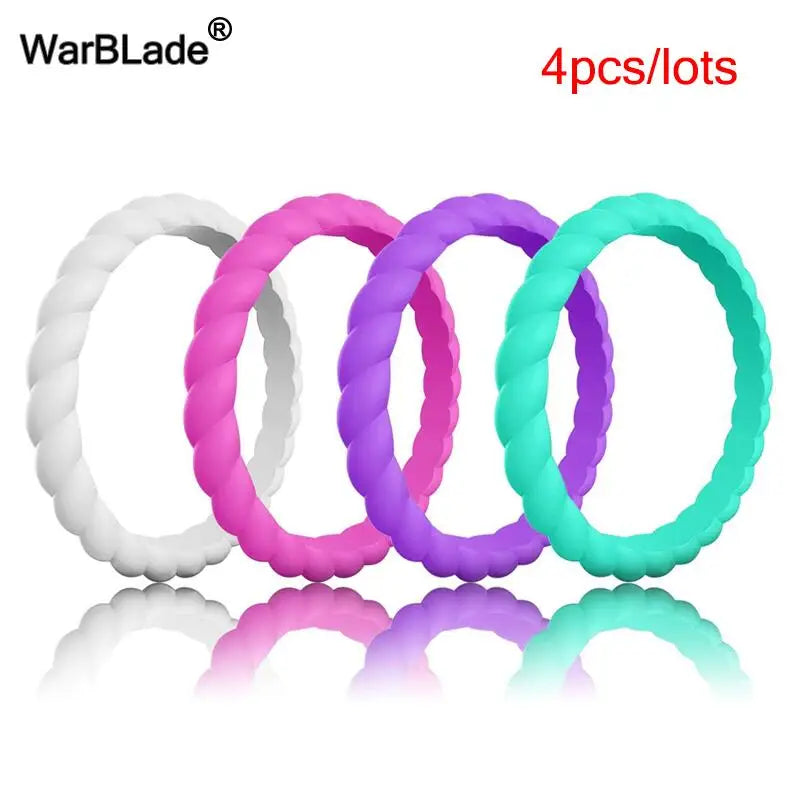 Four silicone rings in white, pink, purple, and teal colors displayed on a reflective surface.
