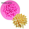 A pink silicone mold shaped like a lotus flower is shown next to a yellow chrysanthemum flower.