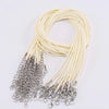 A bundle of thin, cream-colored leather cords with silver clasps coiled in a loop.
