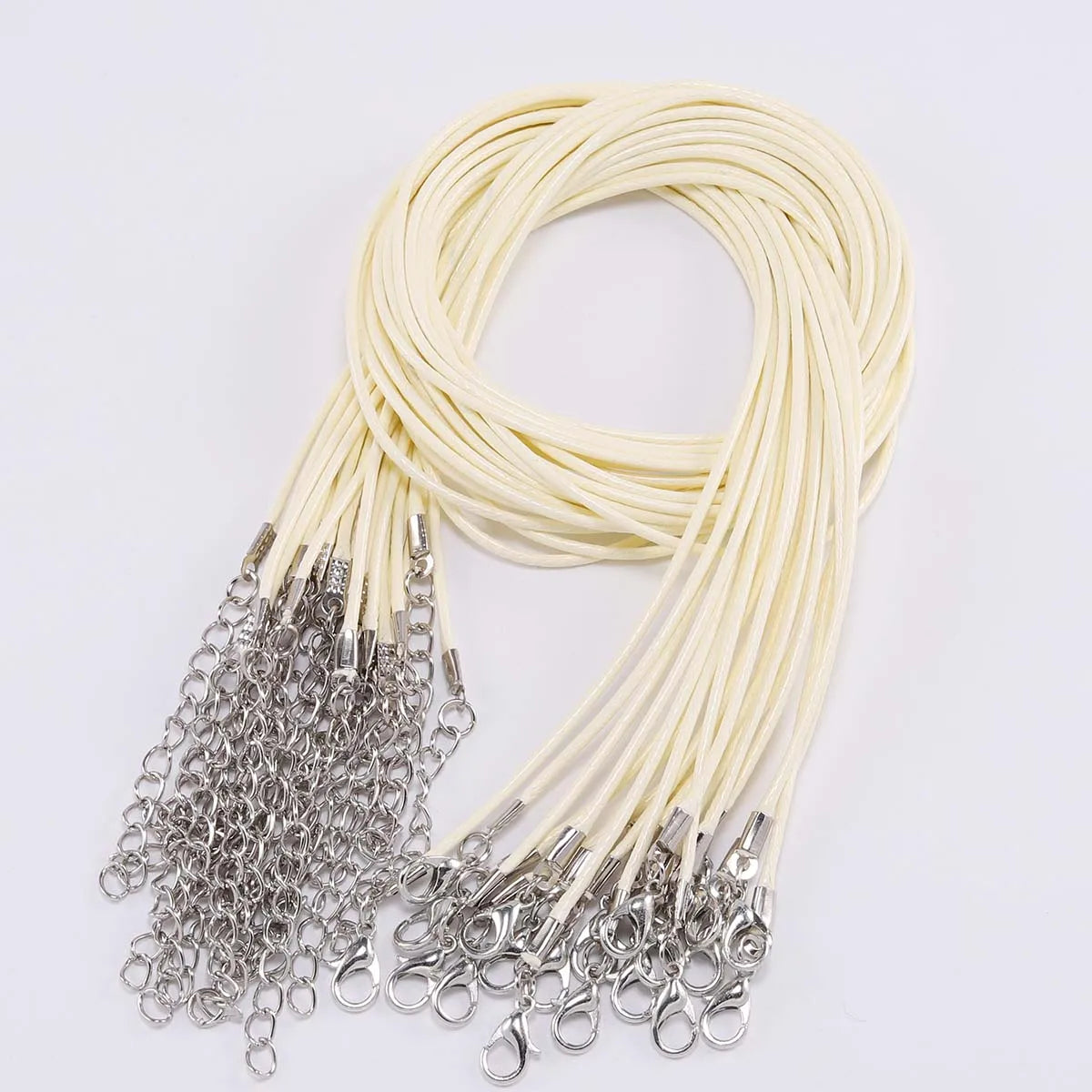 A bundle of thin, cream-colored leather cords with silver clasps coiled in a loop.